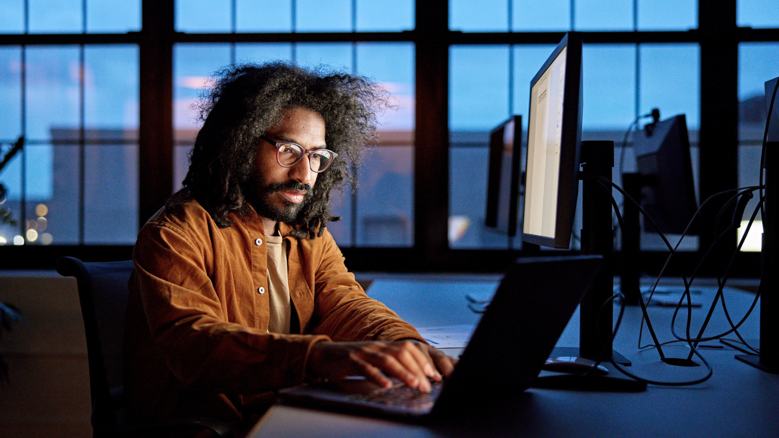 man with glasses and beard working on windows desktop computer