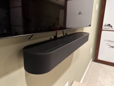 the sonos beam (gen 2) mounted to wall underneath flat-screen tv