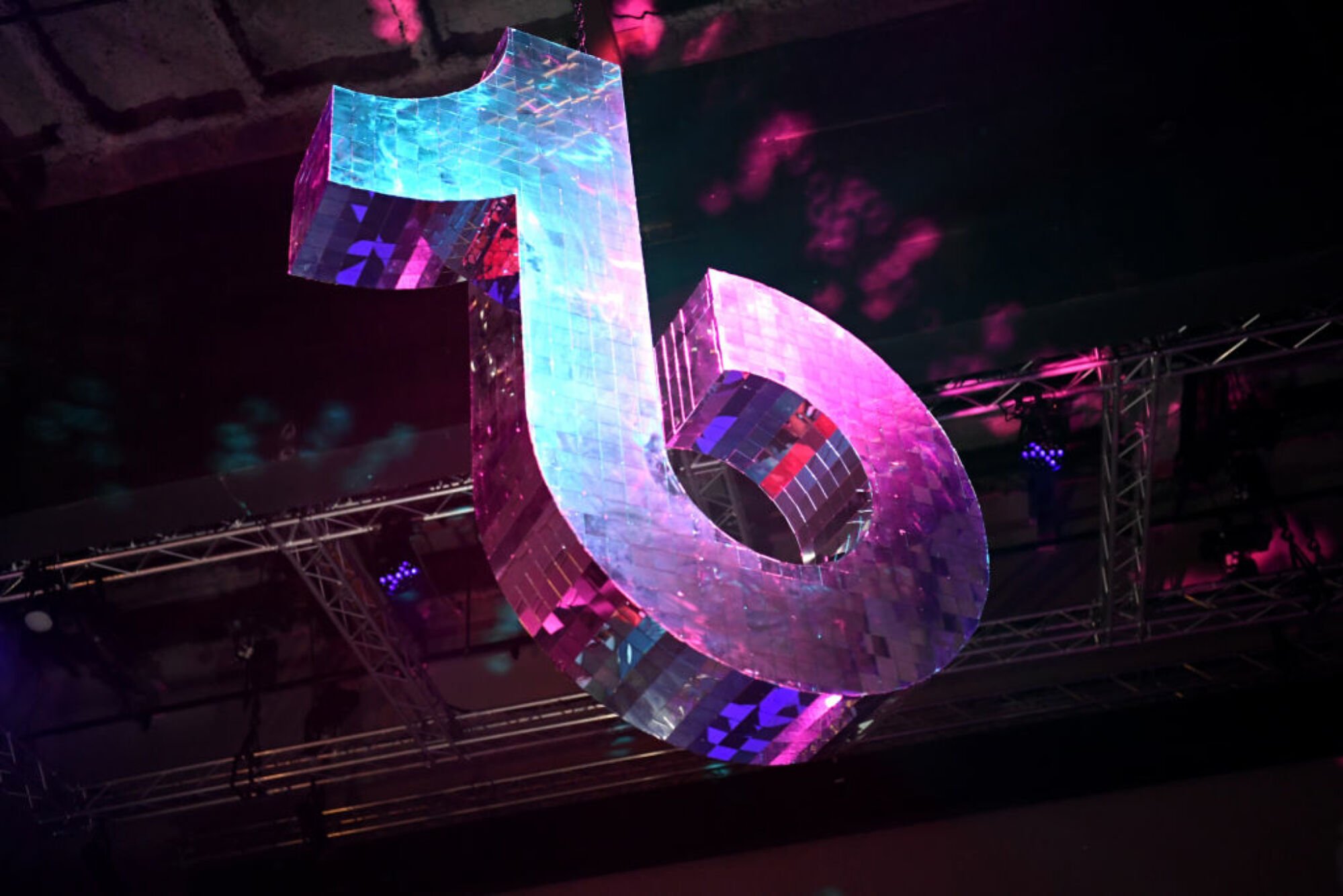 disco ball in the shape of the TikTok logo in a darklit room