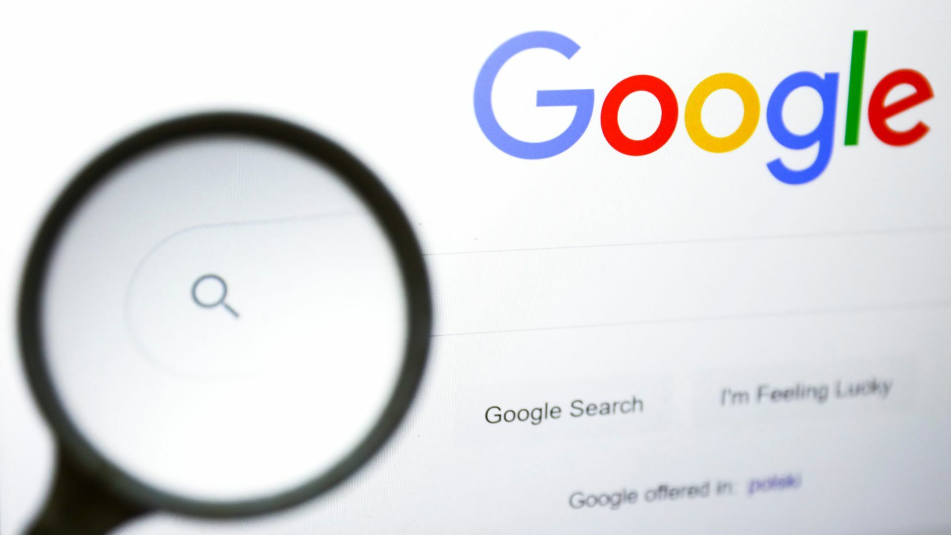 A magnifying glass is photographed with Google logo displayed on a laptop screen for illustration photo.