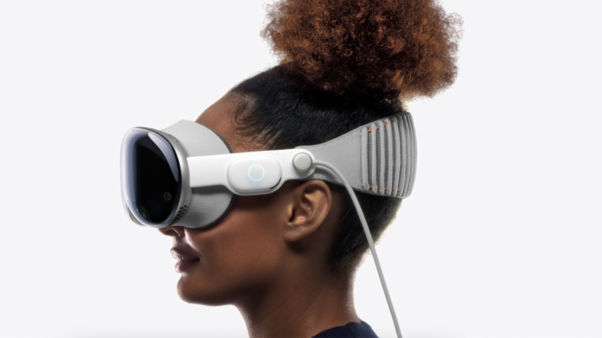 Side profile of Black girl wearing the Apple Vision Pro. She has her hair tied up in a puff.