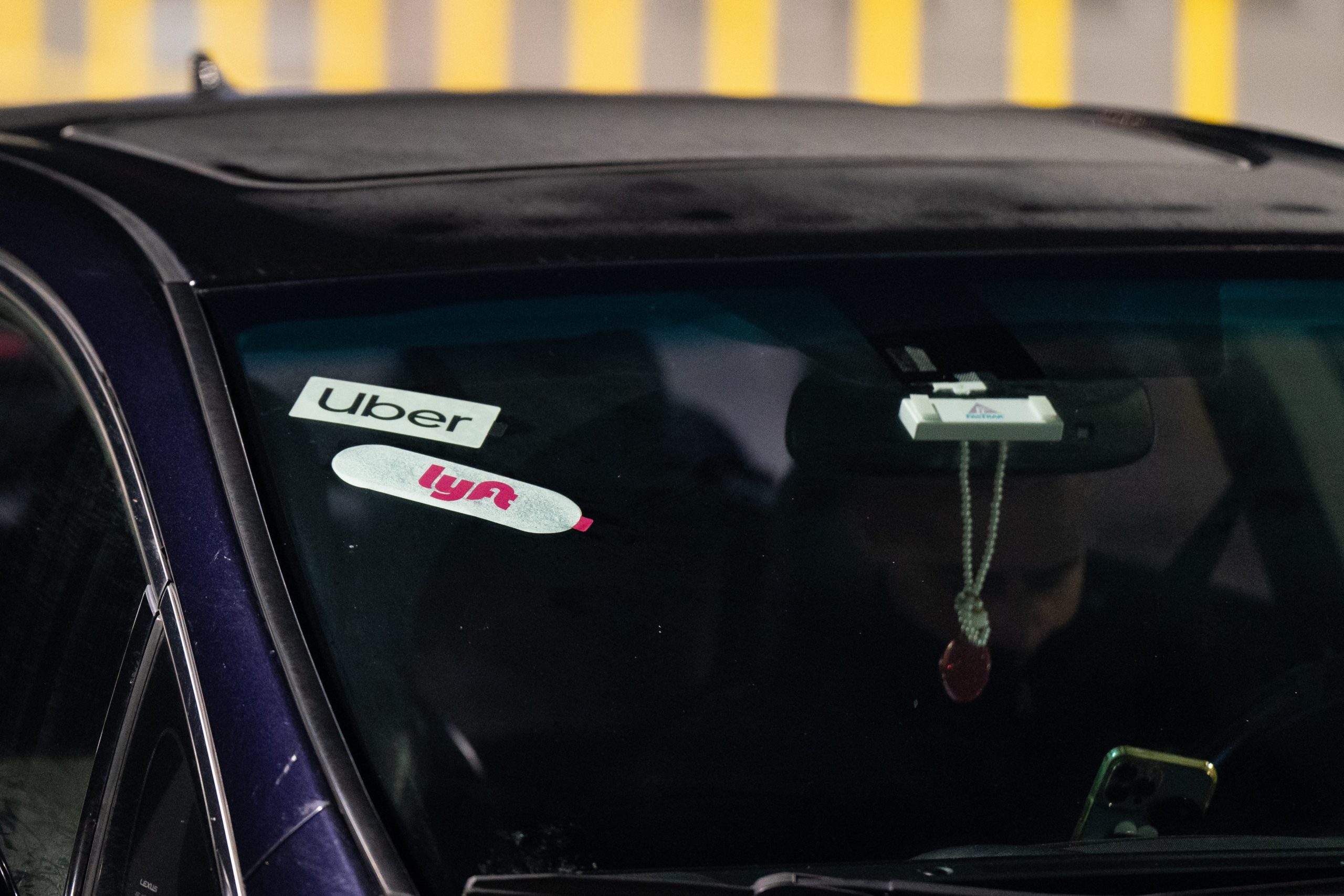 Lyft and Uber signage on a car at San Francisco International Airport (SFO) in San Francisco, California, US, on Thursday, Feb. 8, 2024. Lyft Inc. is scheduled to release earnings figures on February 13.