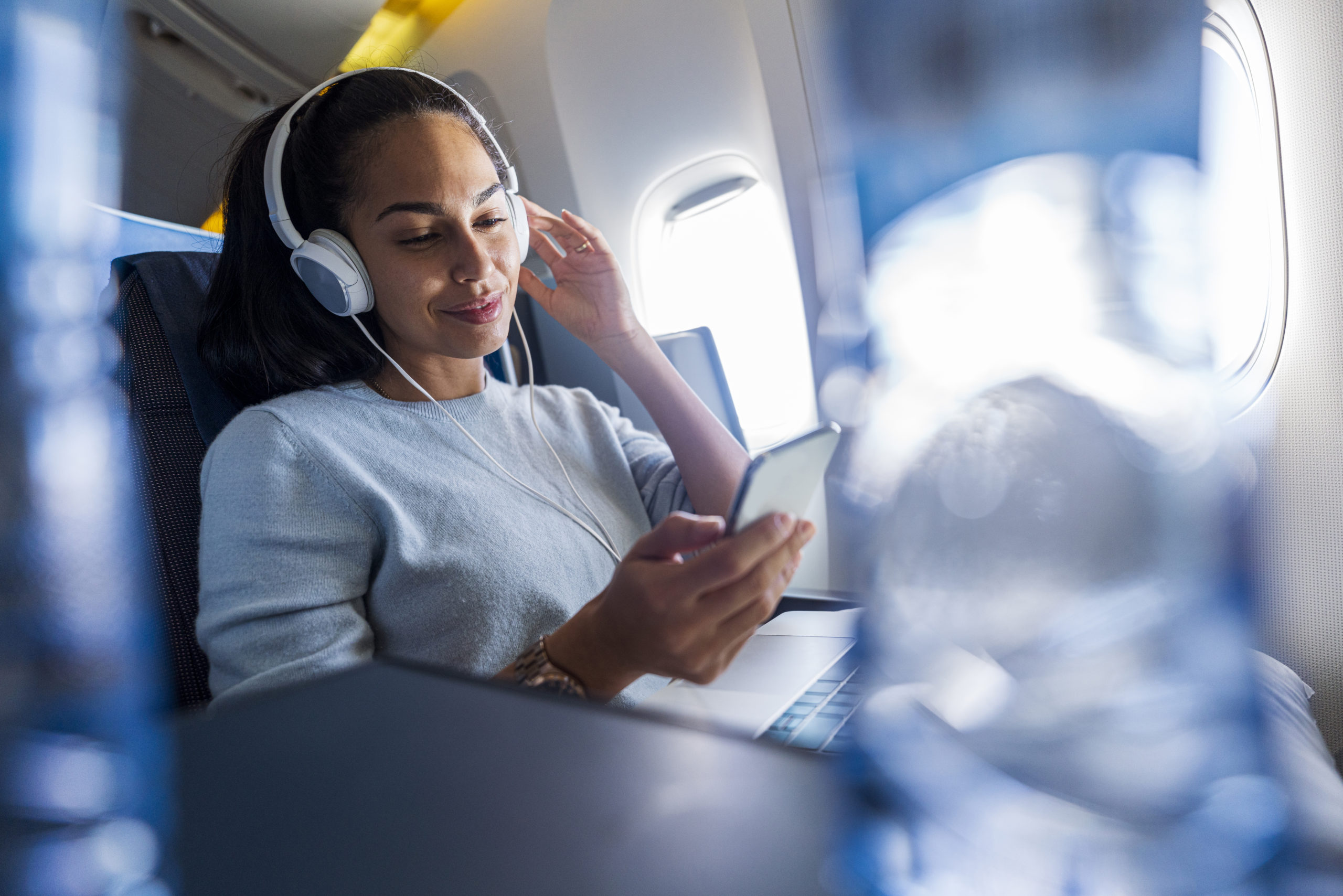 woman using headphones on an airplane