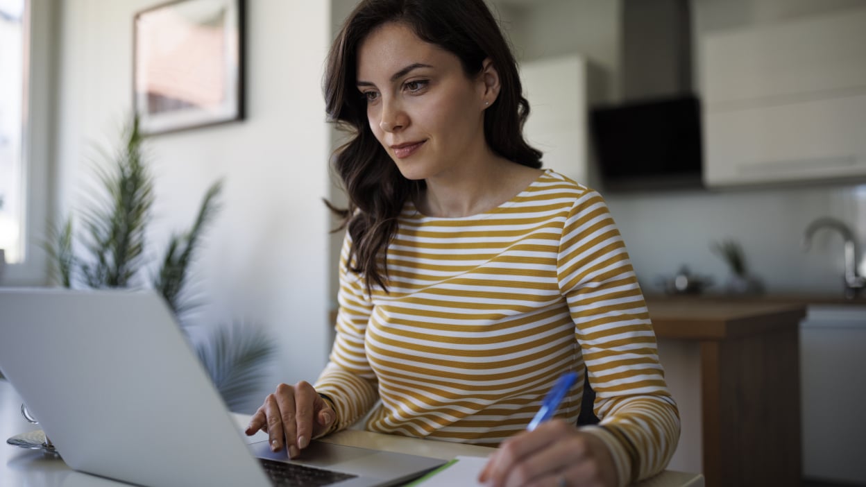 Woman staring at laptop with pen