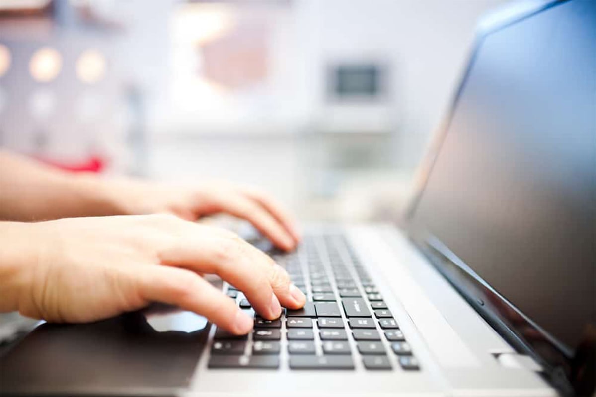 person typing on an Apple MacBook