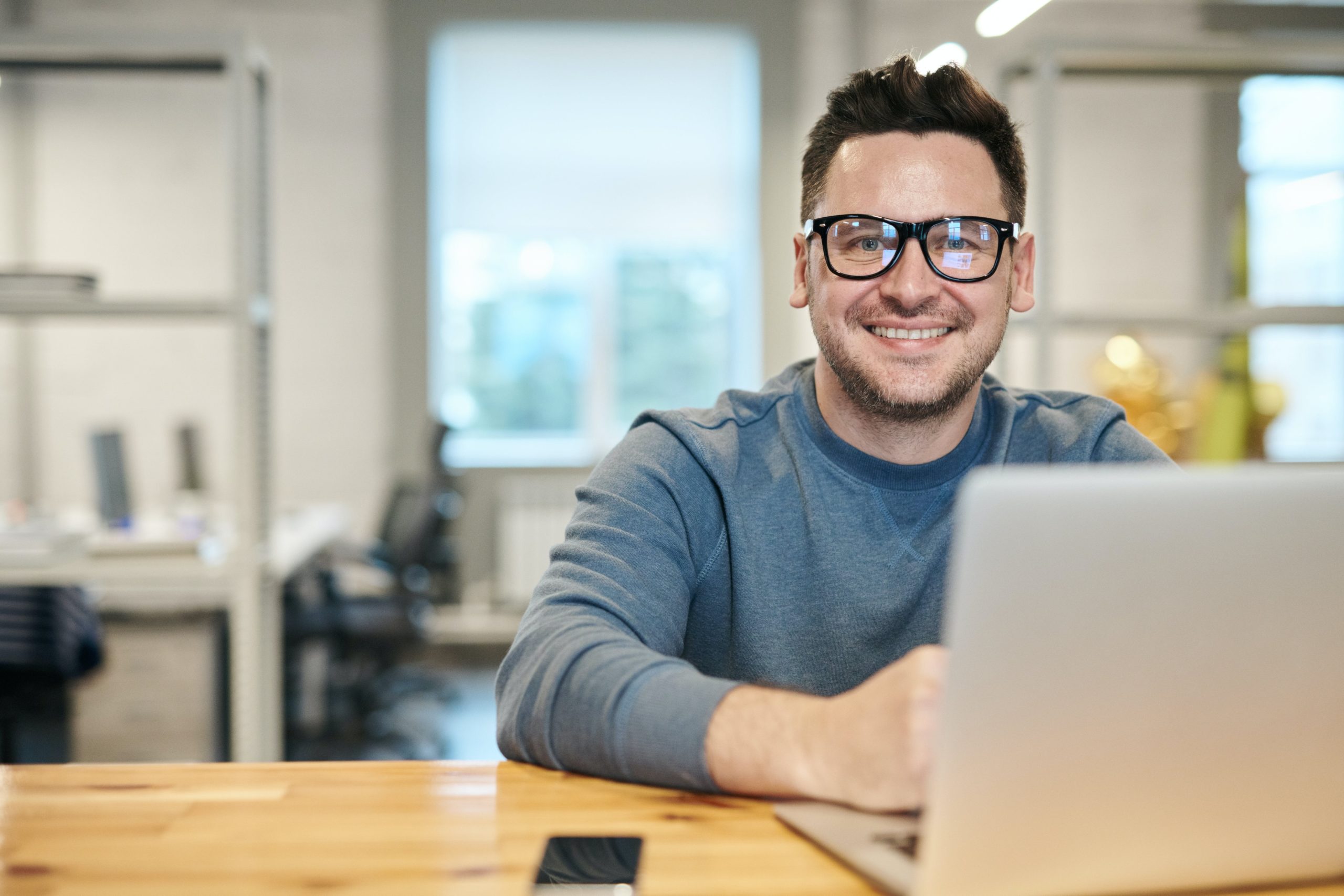 Man smiling in front of laptop