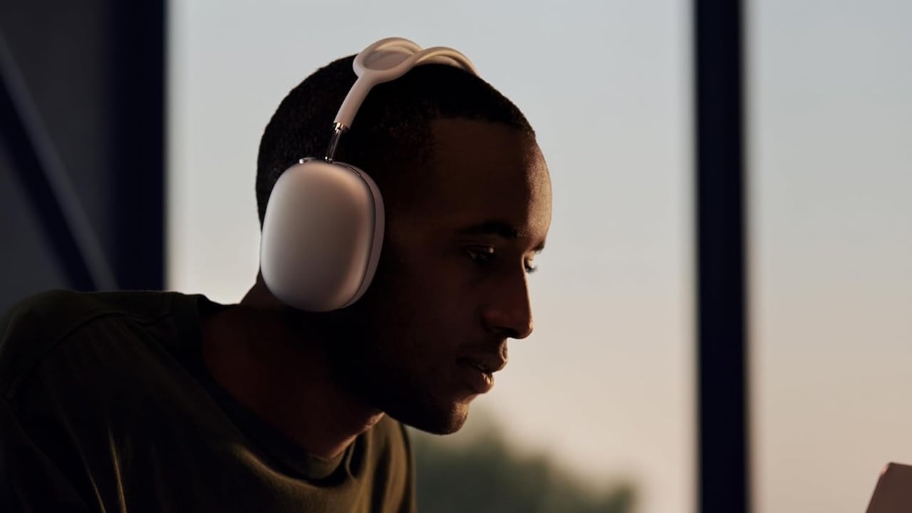 Person sitting at computer and wearing AirPods Max