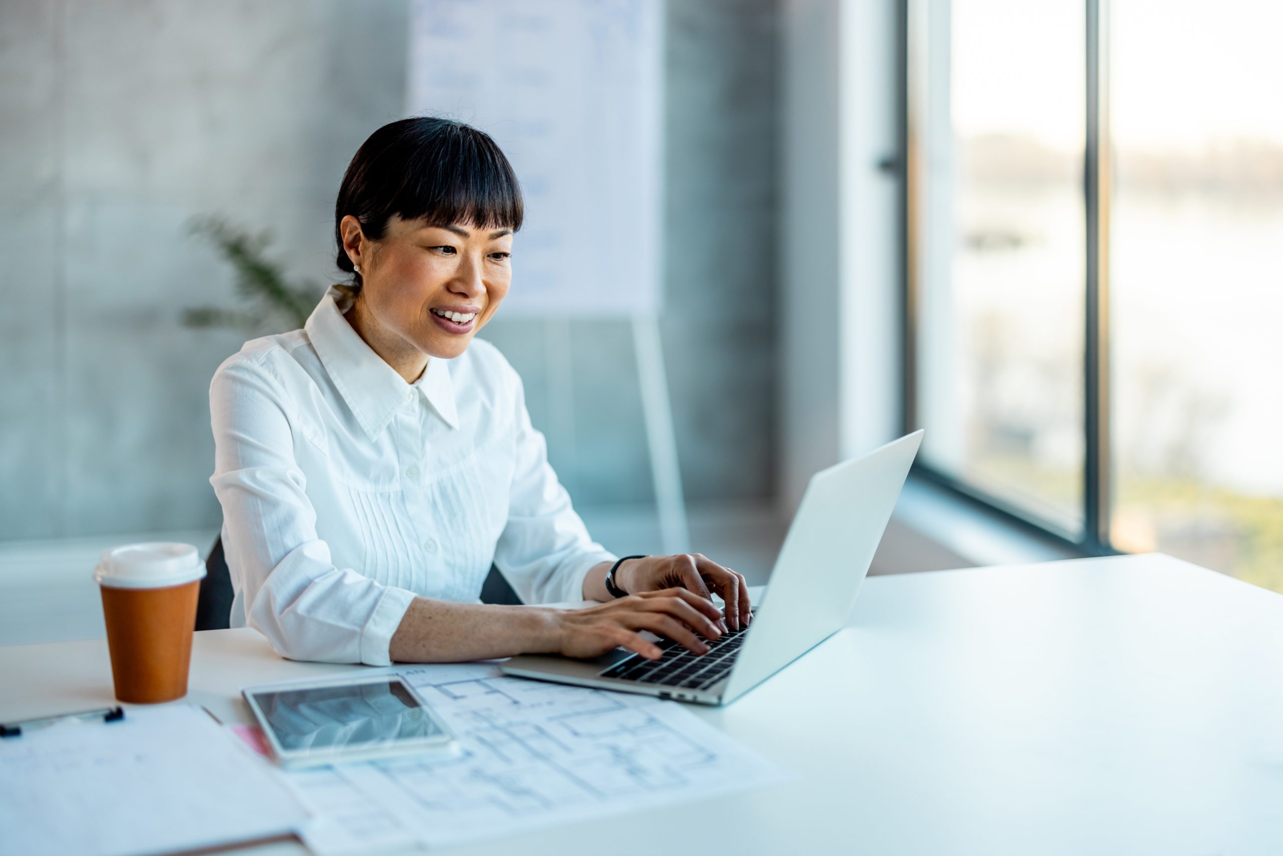 woman smiling in office at computer.