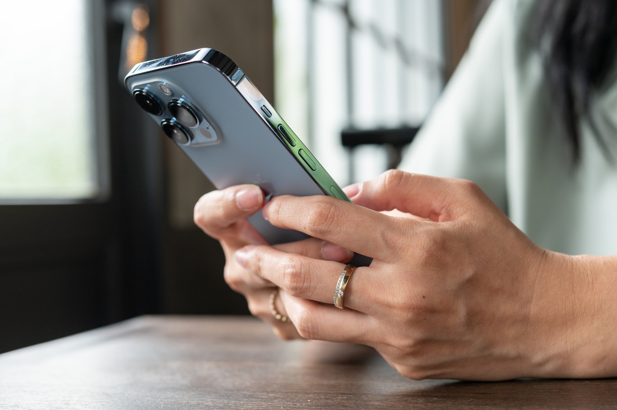 woman's hands holding an iPhone 13 Pro