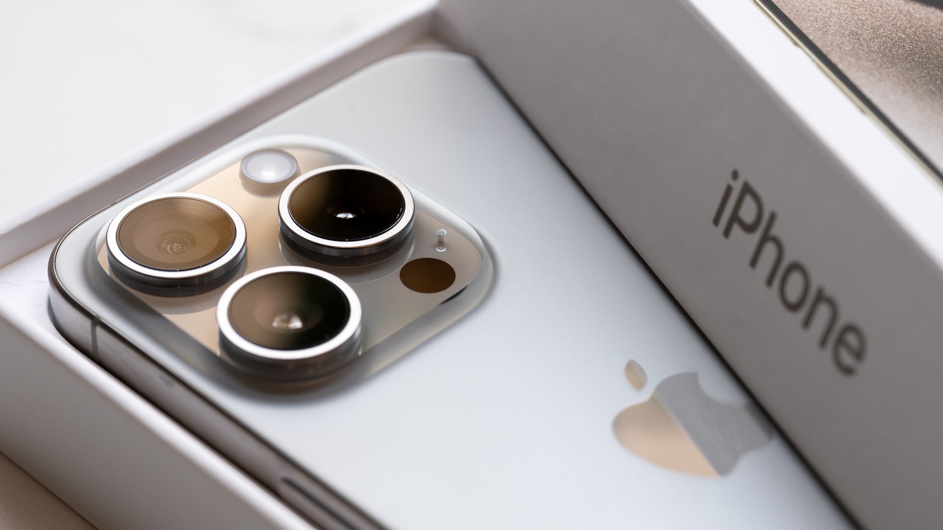 A brand new Apple iPhone 15 pro titanium is displayed with box and packaging.