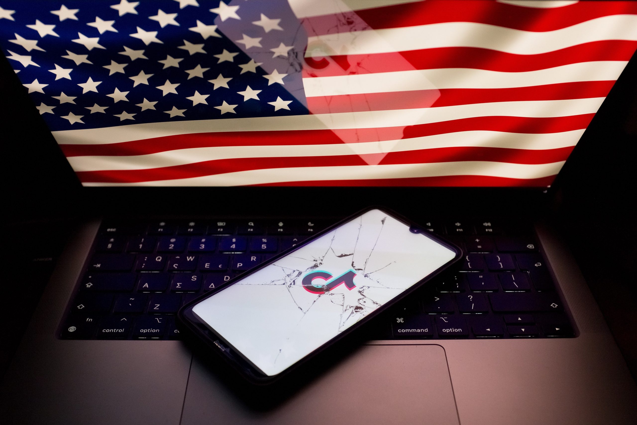 A photo of the U.S. flag and a broken phone screen with the TikTok logo on it 