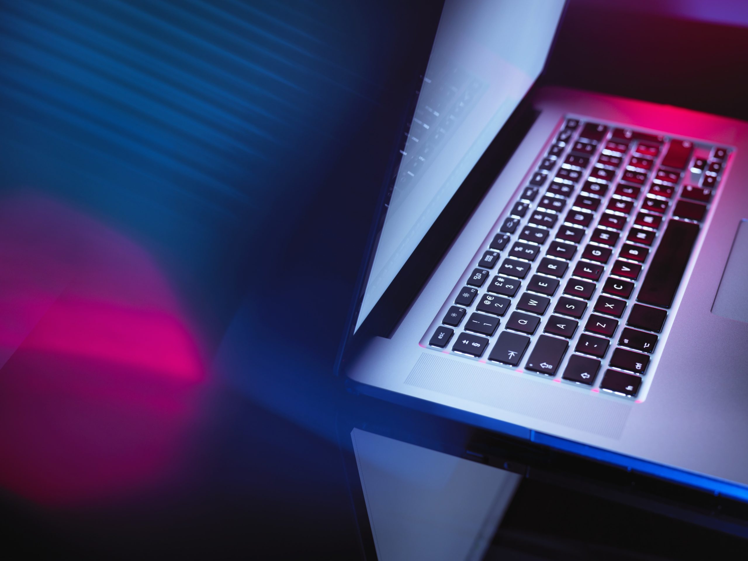A glowing laptop in a dark room. 
