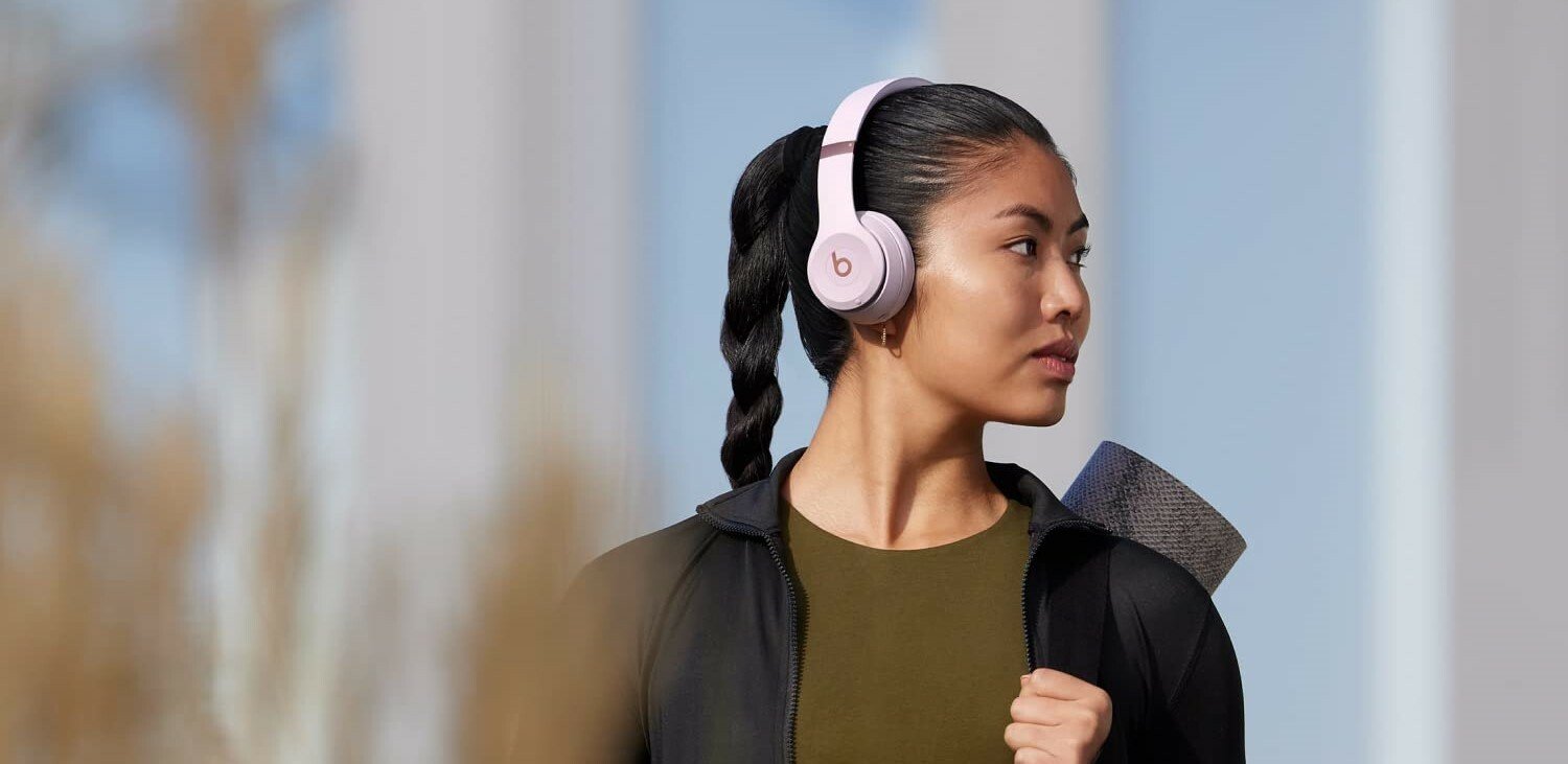 A woman wears a pair of Beats Solo 4