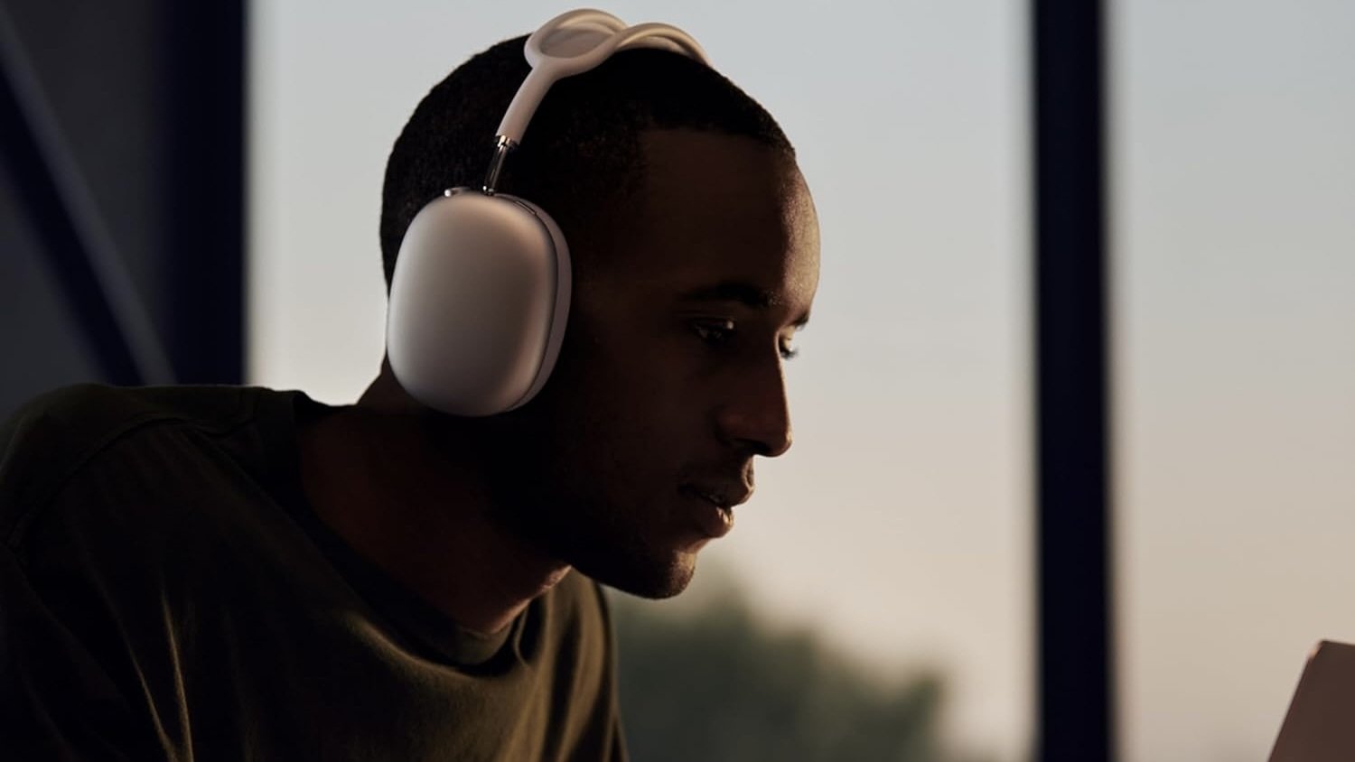 man wearing apple airpods max and leaning in to what he's looking at