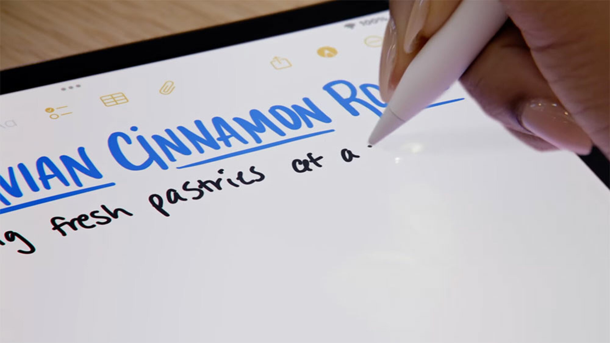 An image of someone writing on an iPad with an Apple Pencil.