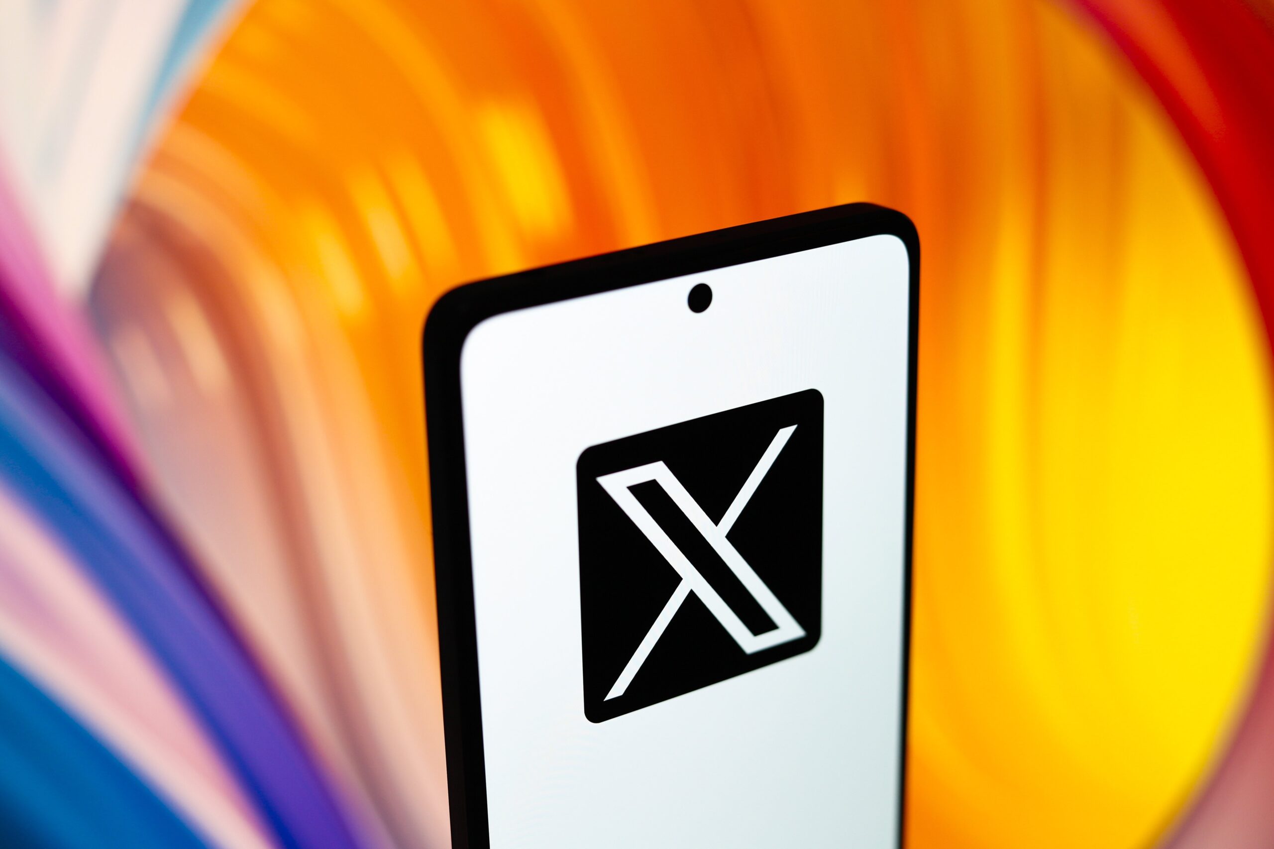 x logo on phone with colorful background