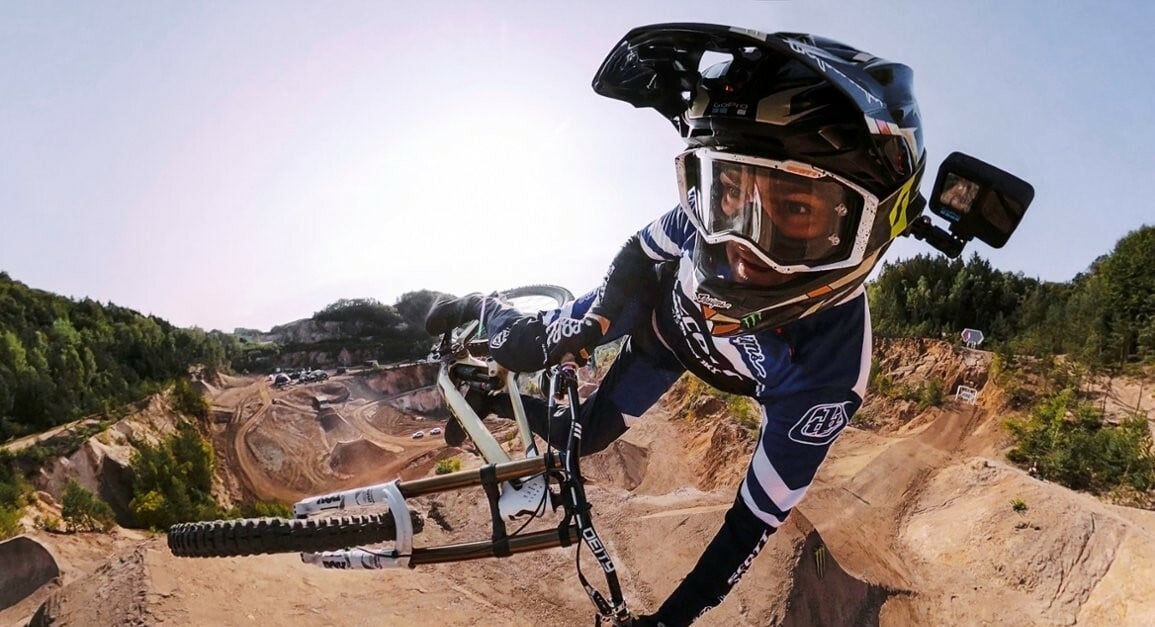 a person riding a bicycle wears a GoPro on their helmet