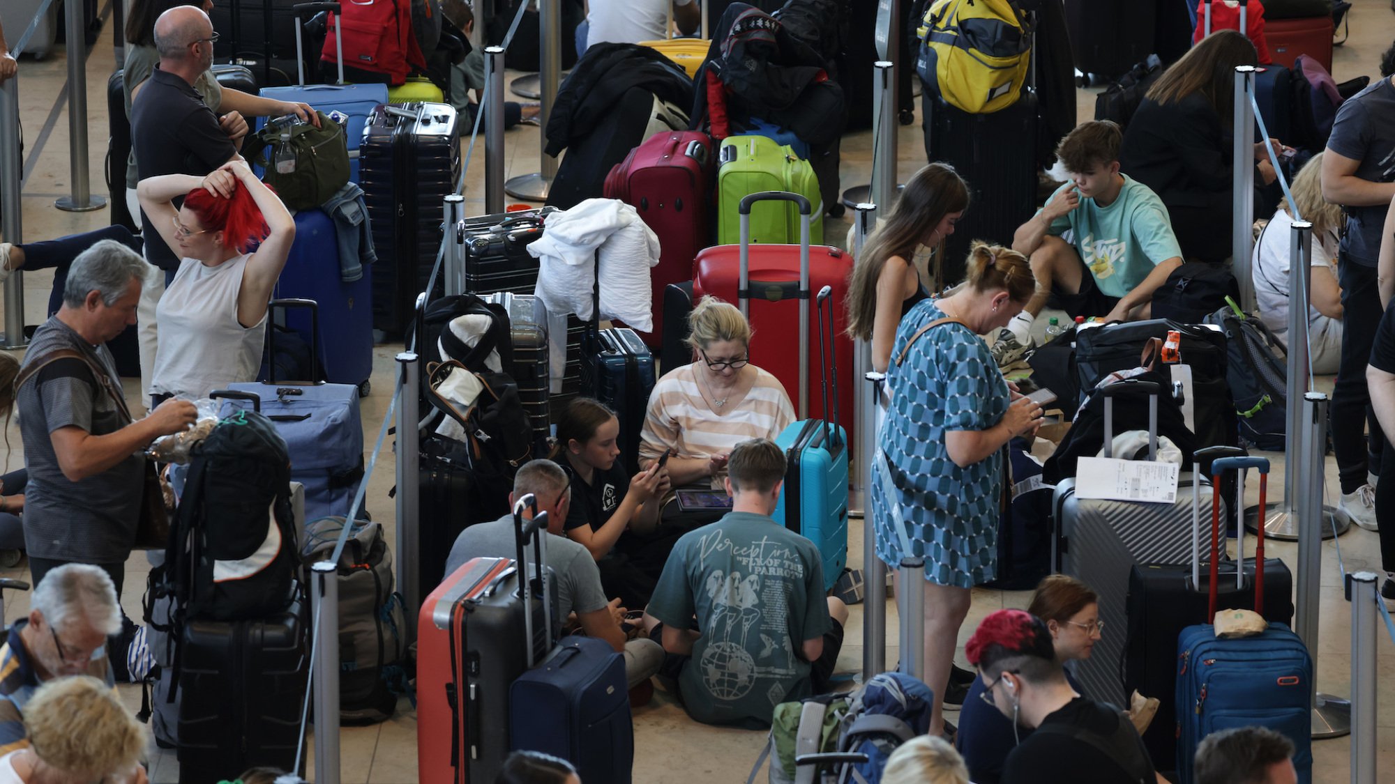 Travellers wait at a check-in counter at Berlin Airport on Friday.