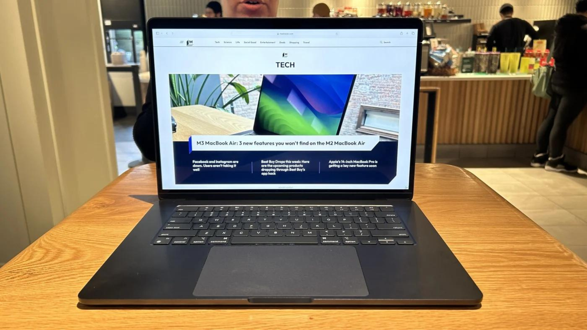 A MacBook Air sitting on a table in a café