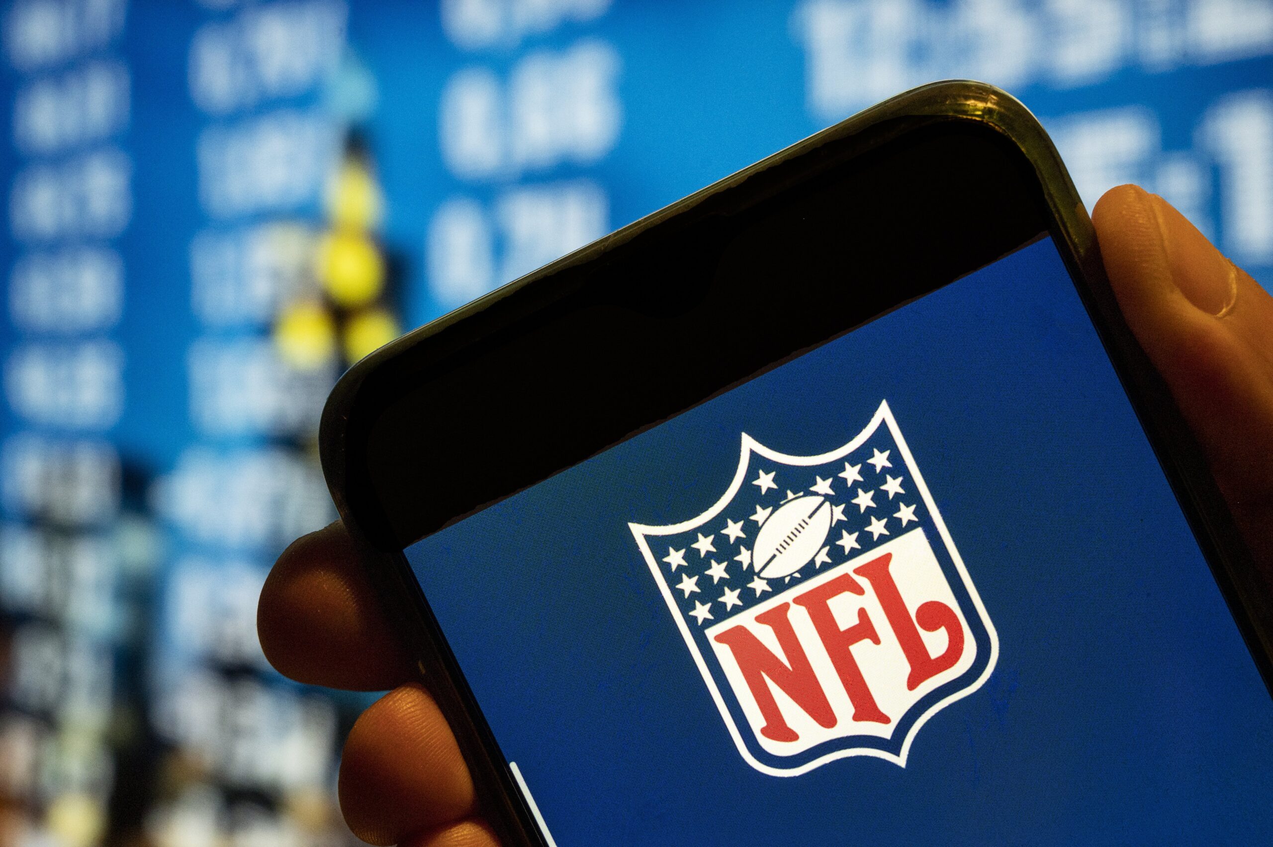 nfl logo on screen of iphone with blue background