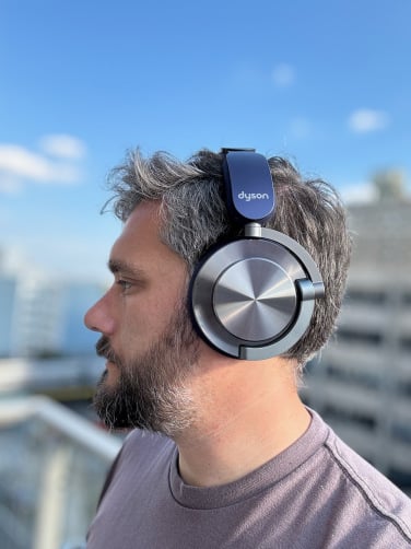 man wearing the dyson ontrac headphones against blue sky