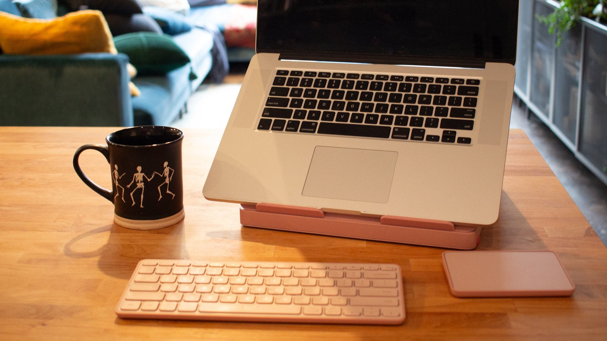 macbook sitting on logitech casa desk stand with keyboard an trackpad sitting nearby