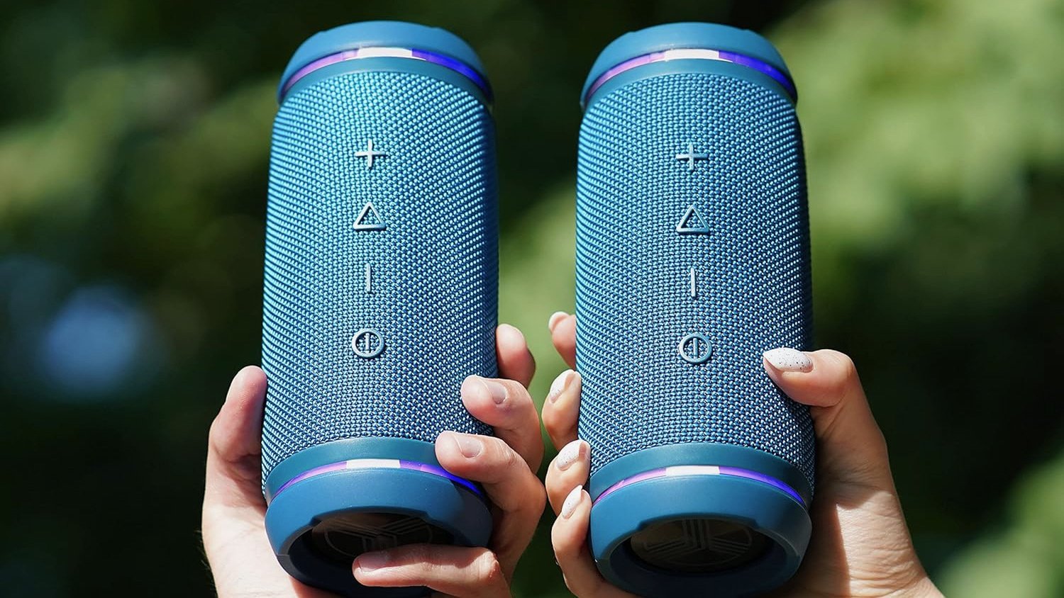 two hands holding the treblab hd77 portable speaker