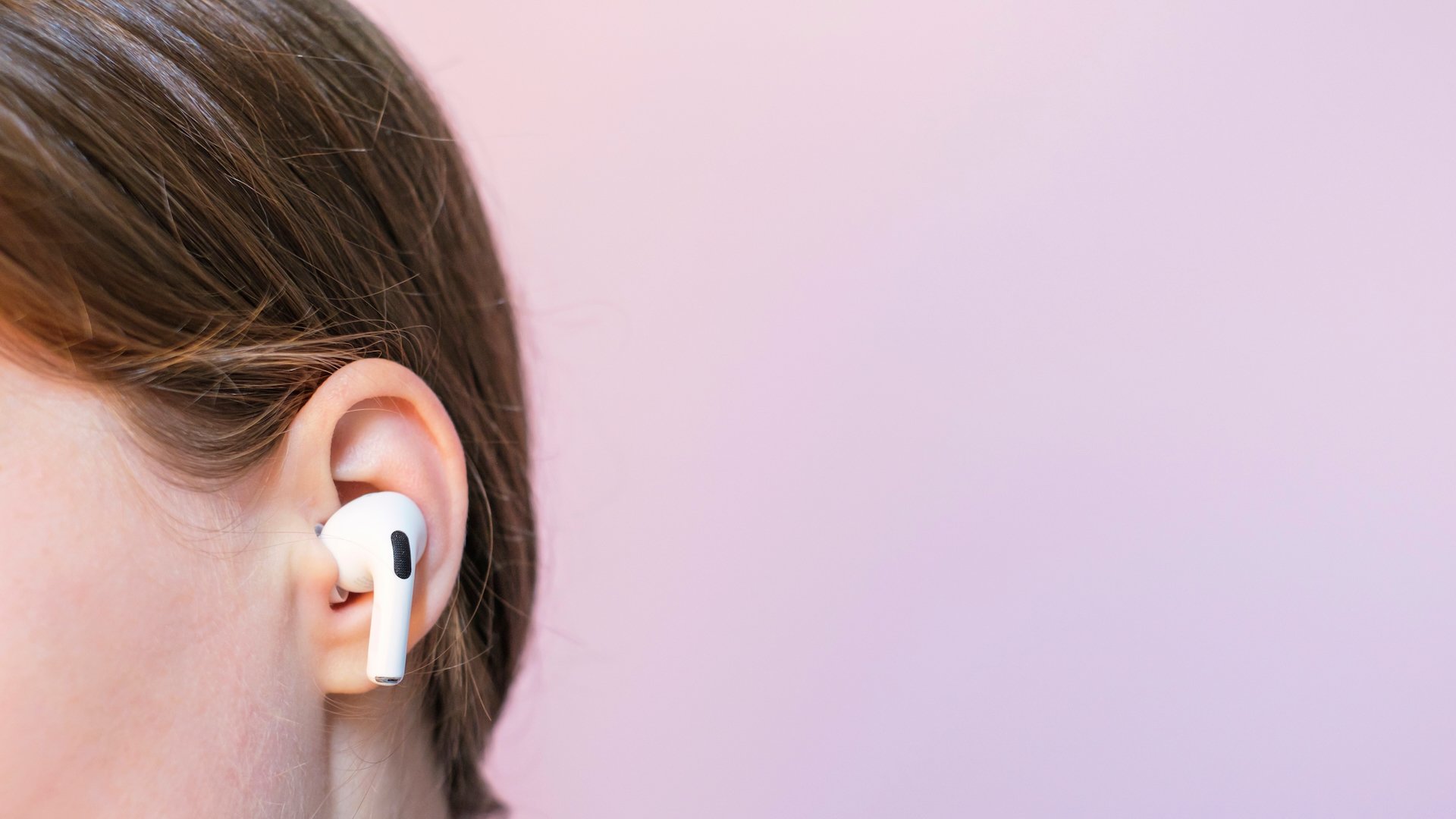 A woman wears an AirPod Pro 2.