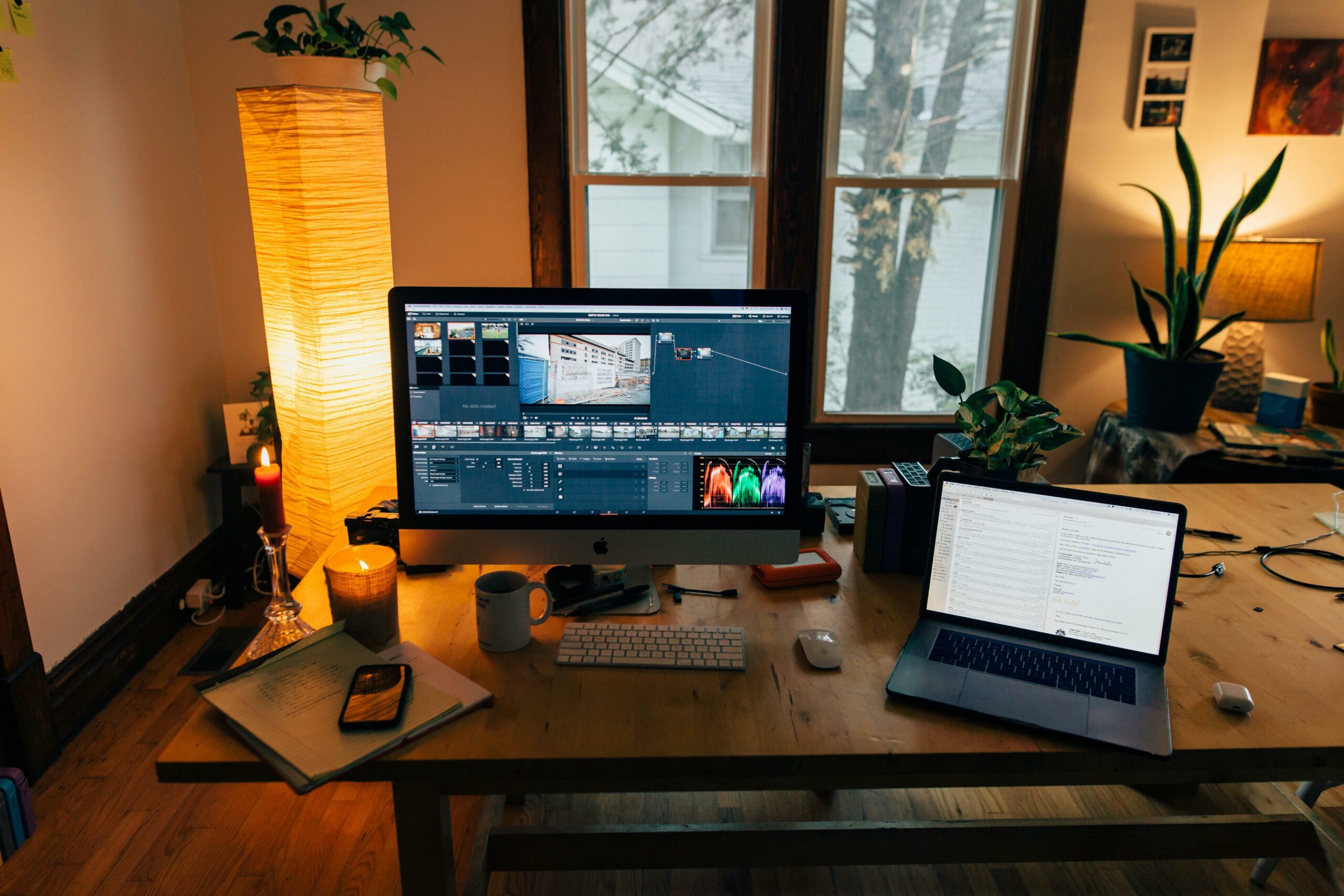 desktop monitor and laptop on crowded desk