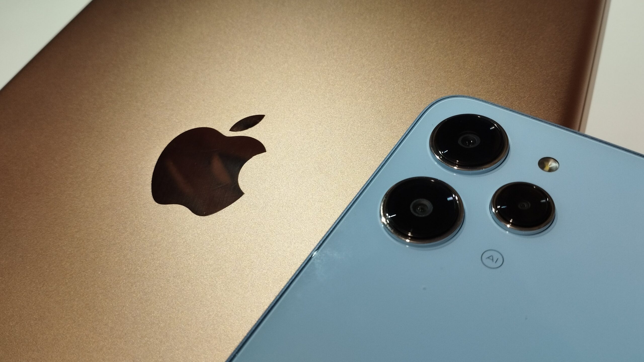 Gold iPad and Xiaomi Redmi 12 Sky Blue color. Close-up. Concept of Confrontation between Apple and Xiaomi.