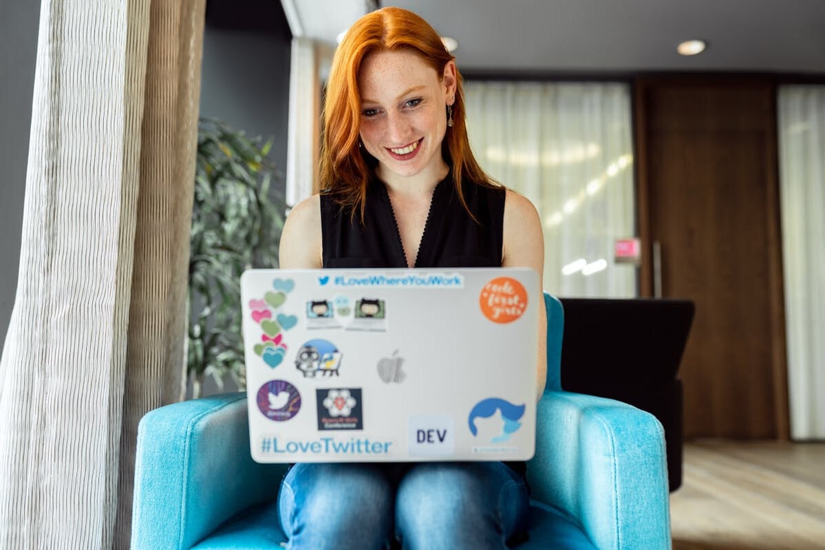 woman working on laptop covered in stickers