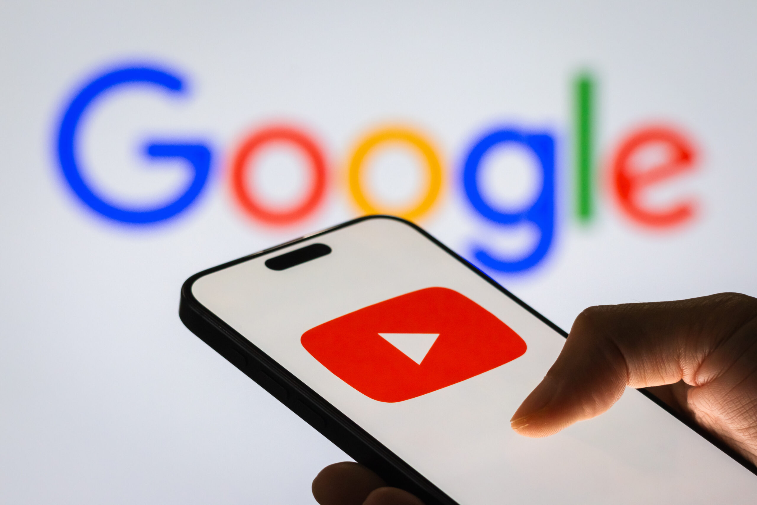 A smartphone screen displays the YouTube app logo, with the Google logo in the background, on November 6, 2024 in Chongqing, China. YouTube, owned by Google, remains a dominant video-sharing platform worldwide, continuously expanding its features and services to enhance user engagement and content discovery.