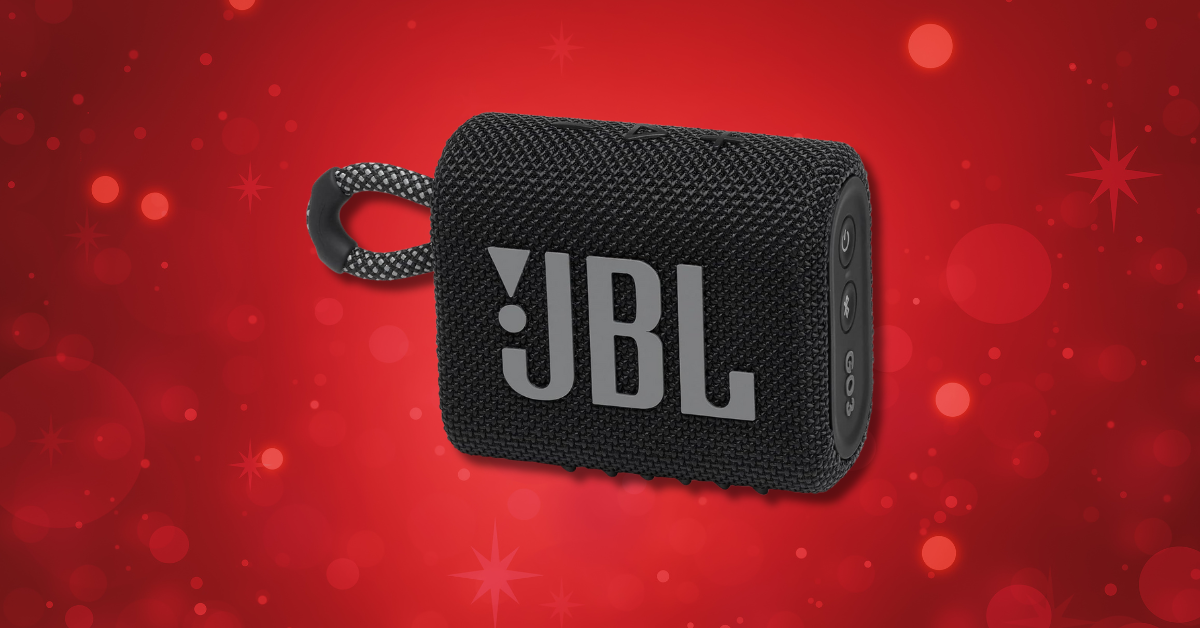 A small, black JBL Go 3 portable Bluetooth speaker with a fabric loop on a red background with festive sparkles.