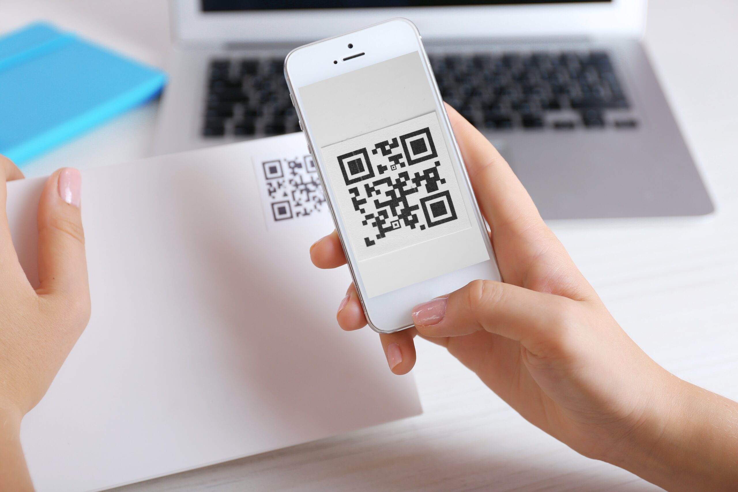 QR code on a piece of paper with person scanning it on their phone
