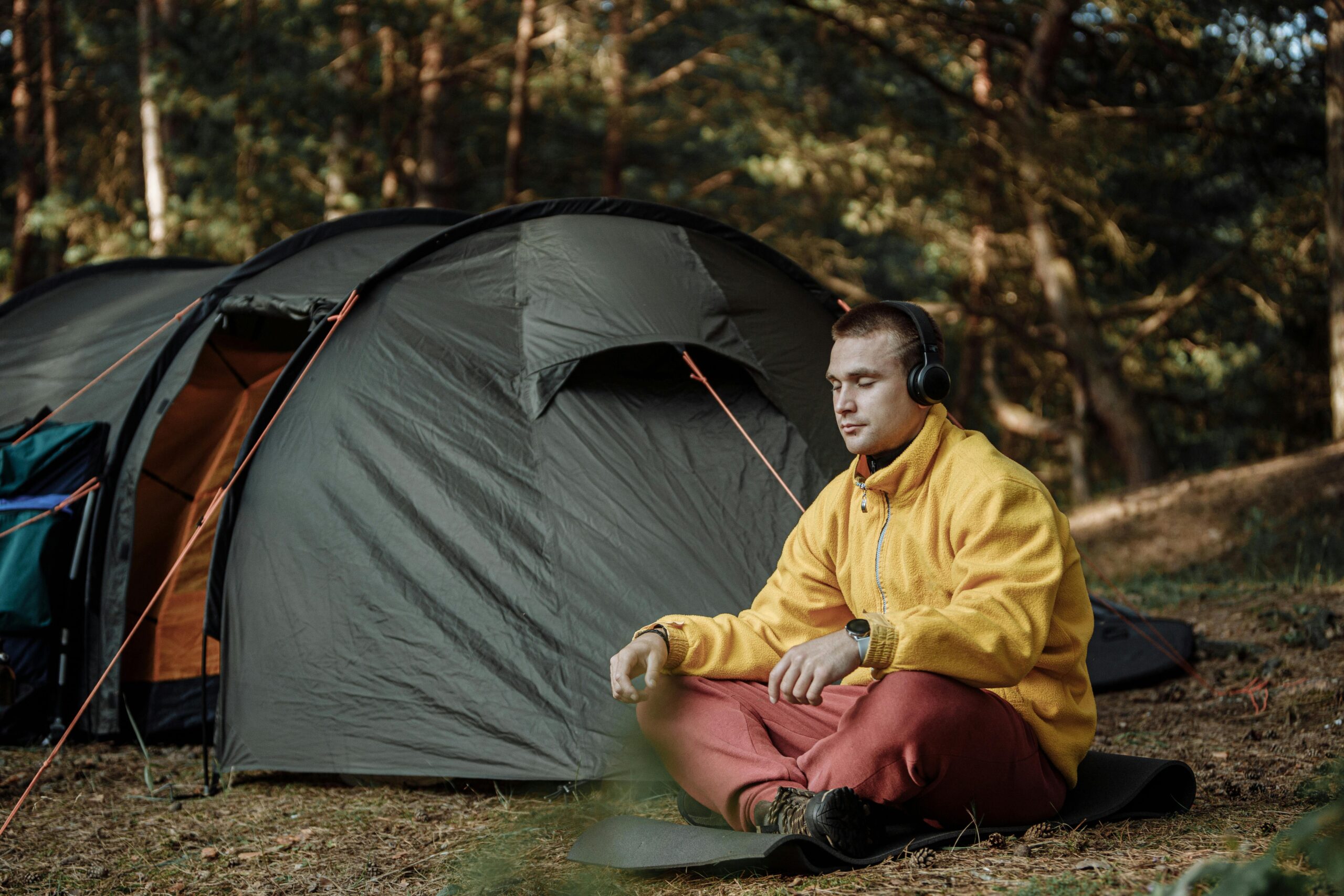 Man listening to headphones outside tent