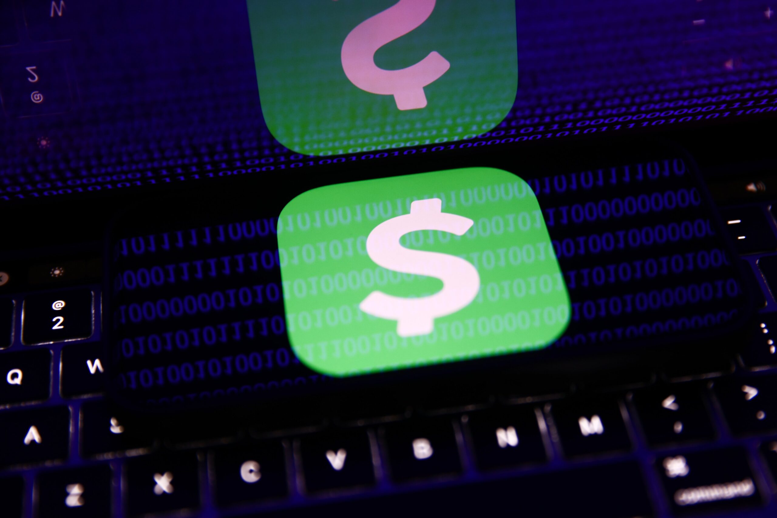 A phone screen displays a digital payment app logo and reflects back glowing blue lines of binary code.