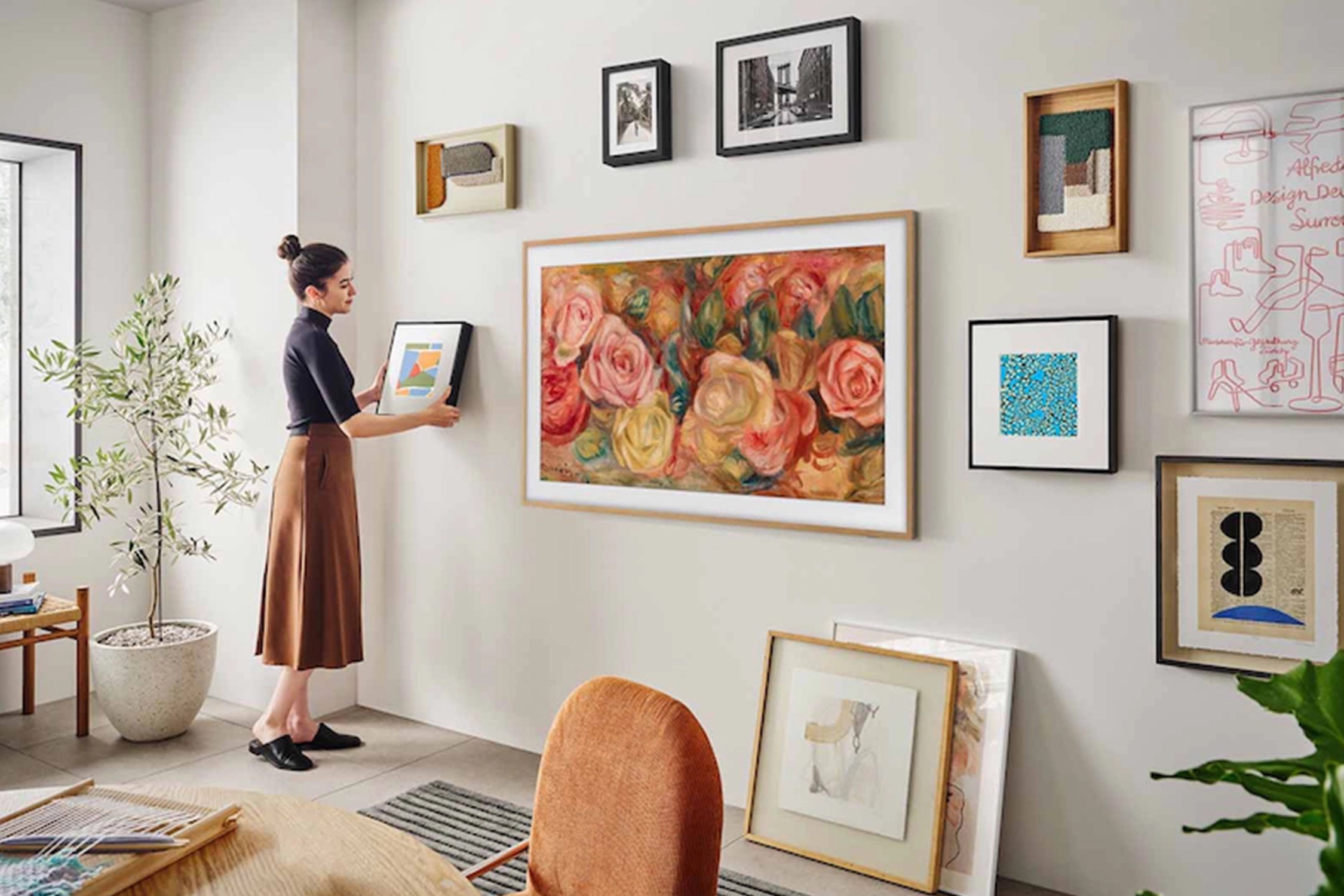 woman hanging Samsung The Frame tv on wall