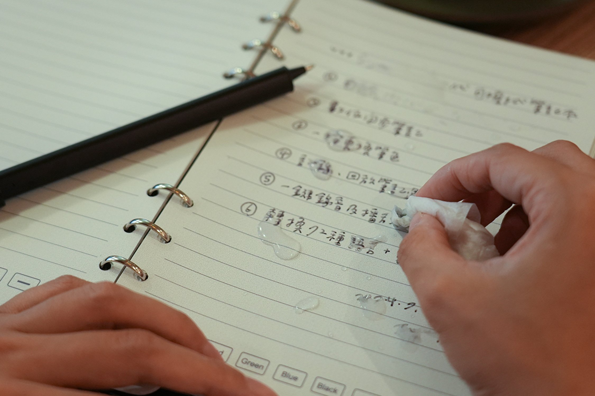 person writing with SyncPen set on notebook paper