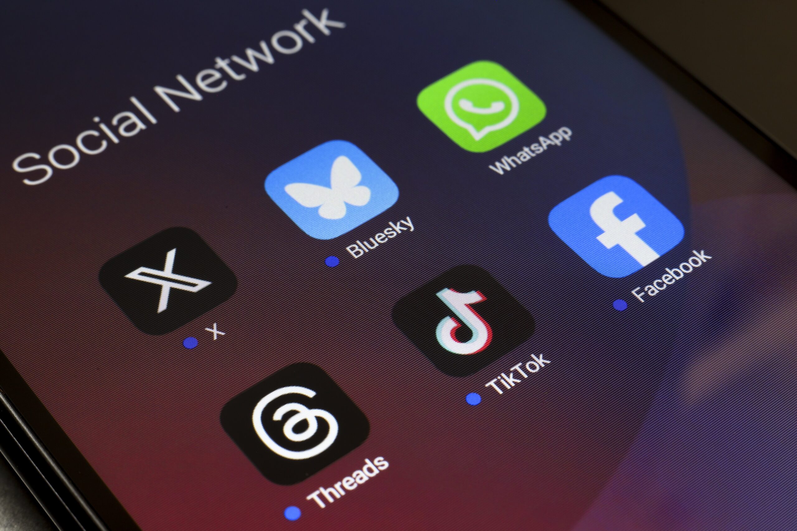 The logos of the social networks X (Twitter), Bluesky, WhatsApp, Threads, TikTok, and Facebook are displayed on the screen of a smartphone in Reno, United States, on November 20, 2024.