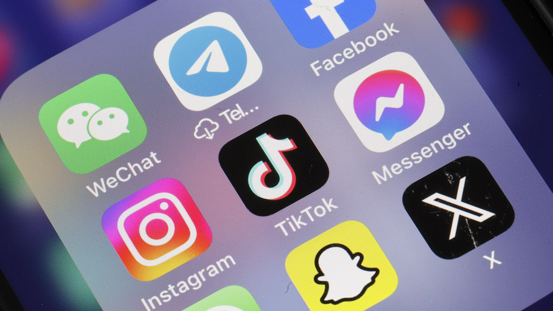 In this photo illustration, WeChat, Telegram, Facebook, Instagram,TikTok Messenger, Snapchat and X applications logos are displayed on the screen of an iPhone .