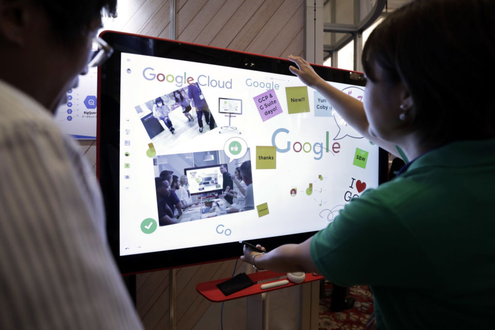 A booth attendant, right, explains Google Inc.'s Jamboard to an attendee at SoftBank World 2017 in Tokyo, Japan,