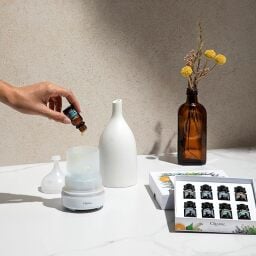 person putting essential oils in a diffuser