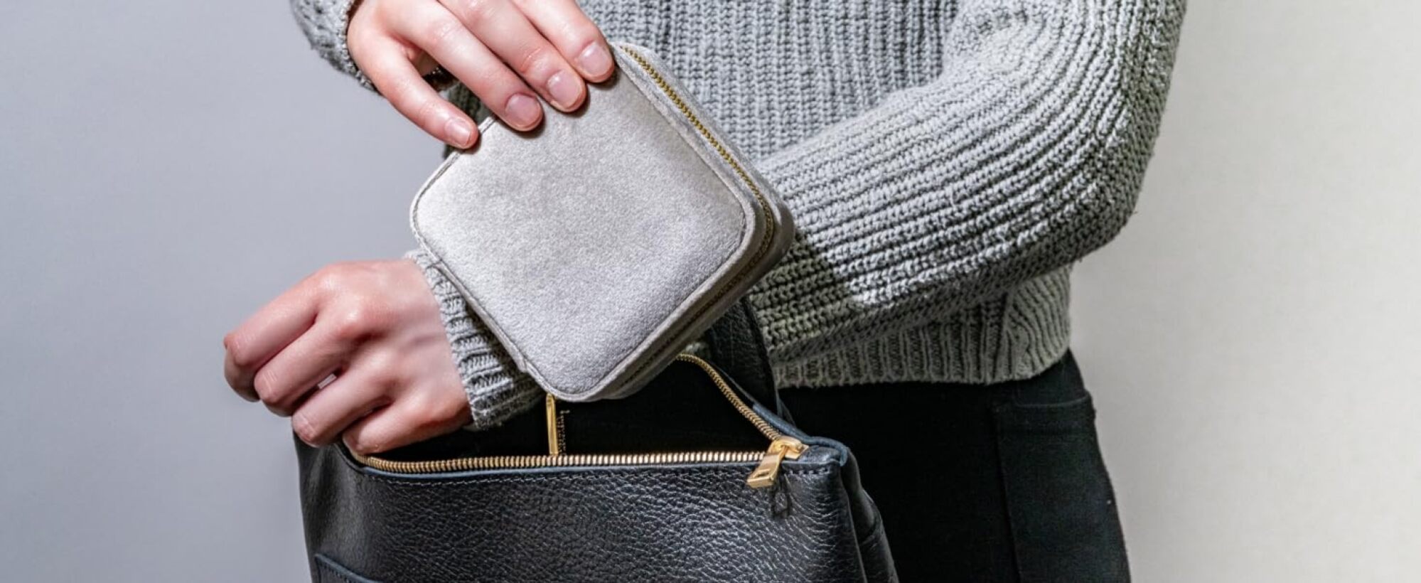 person putting jewelry box into a bag