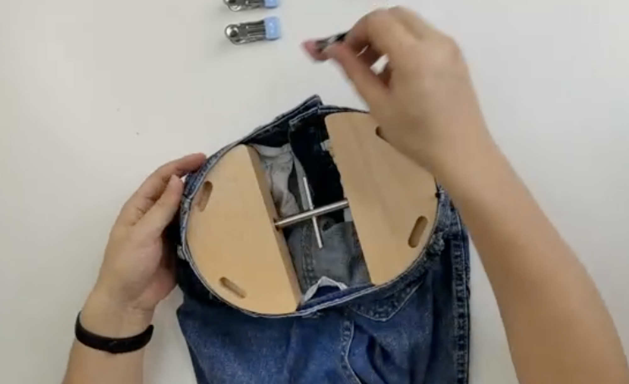 person putting pants stretcher into jeans