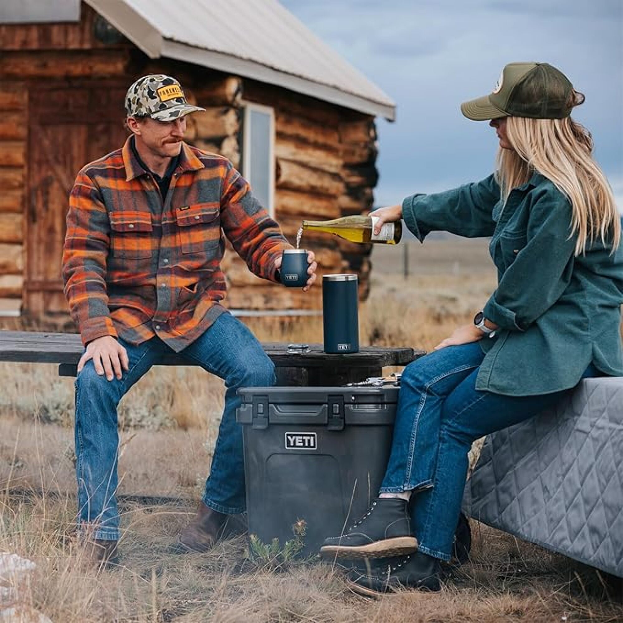 one person pouring another a tumbler of wine