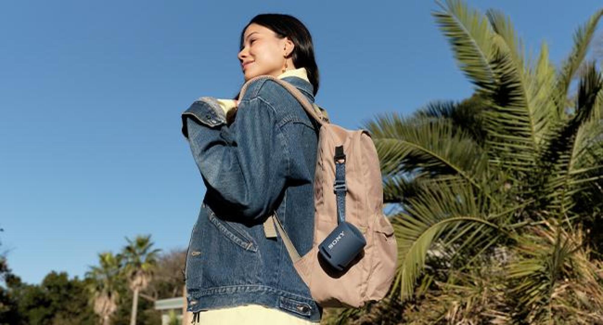 woman carrying backpack with speaker attached