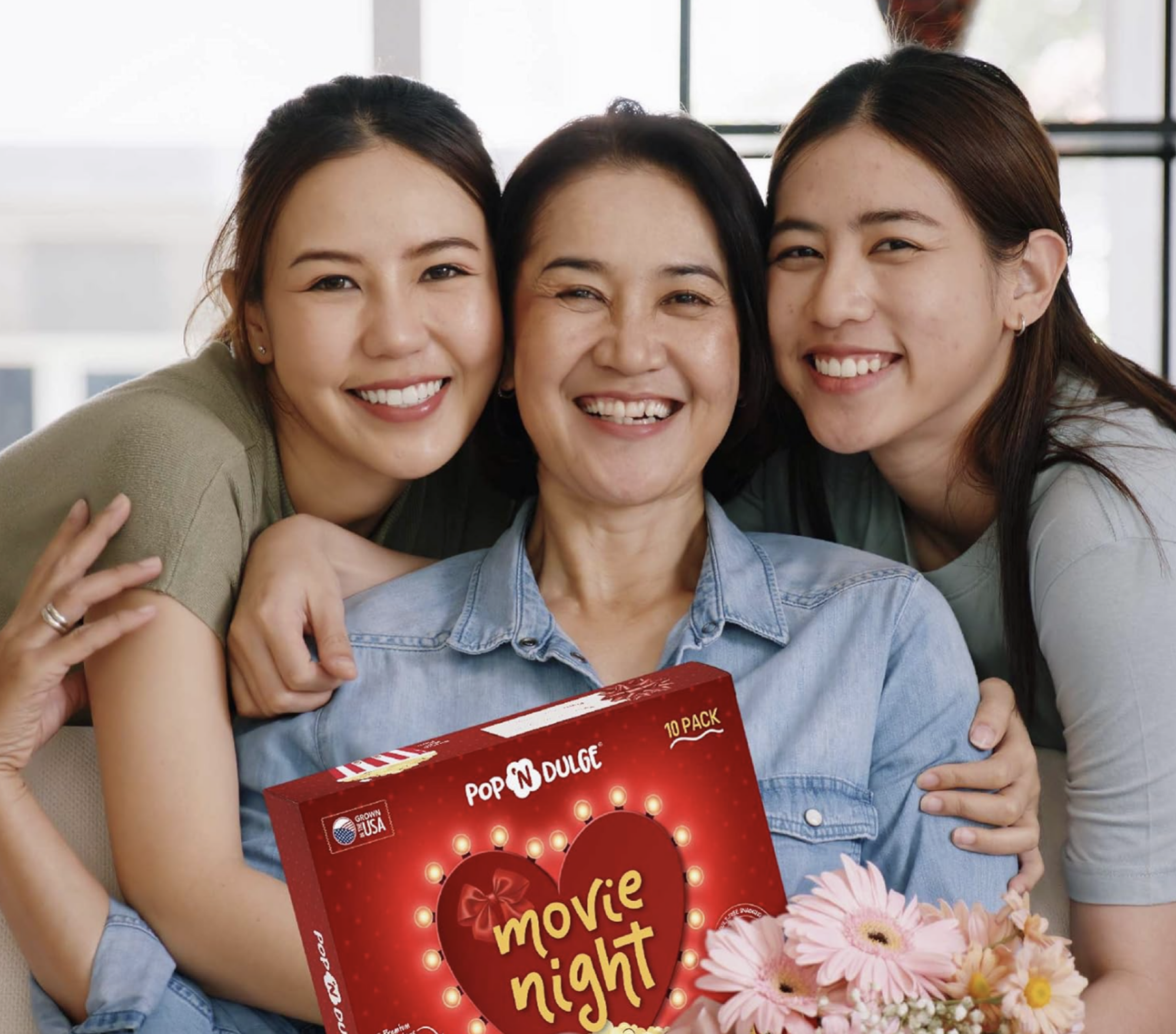 three women holding popcorn box