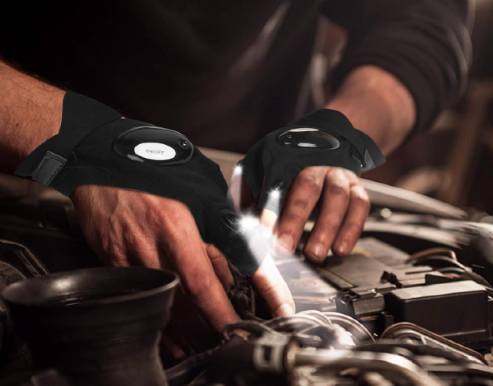 person using flashlight gloves while fixing a car