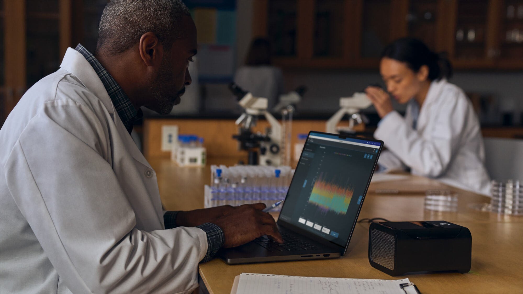M4 MacBook Pro lifestyle image featuring professionals in lab coats