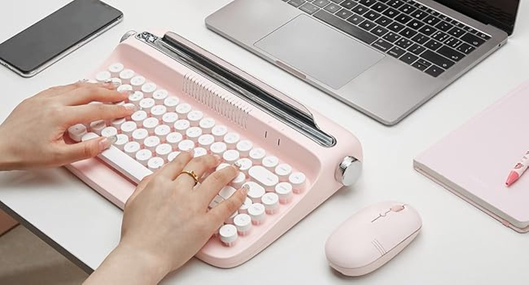 hands typing on pink keyboard